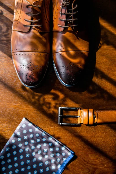 Men\'s shoes, handkerchief, belt. On a wooden surface. Morning cooking.