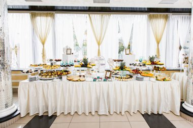 Açık büfede leziz tatlılar. Düğün töreninde bir sürü farklı şekerlemeli çikolata. Tatlı, kurabiye, şeker konseptinin ayrıntıları..