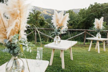 Düğün masası boho tarzında hazırlanmış, otlar ve yeşillikler, yumuşak odak