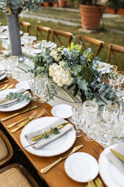 Çatal ve kaşıkla süslenmiş tabak. Pampa otları ve yeşillik ile boho tarzı bir masa hazırlandı.