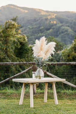 Düğün masası boho tarzında hazırlanmış, otlar ve yeşillikler, yumuşak odak