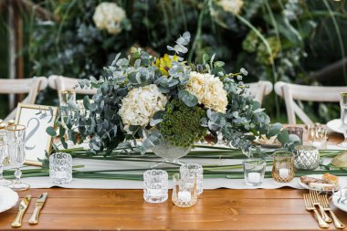 Düğün masası boho tarzında hazırlanmış, otlar ve yeşillikler, yumuşak odak