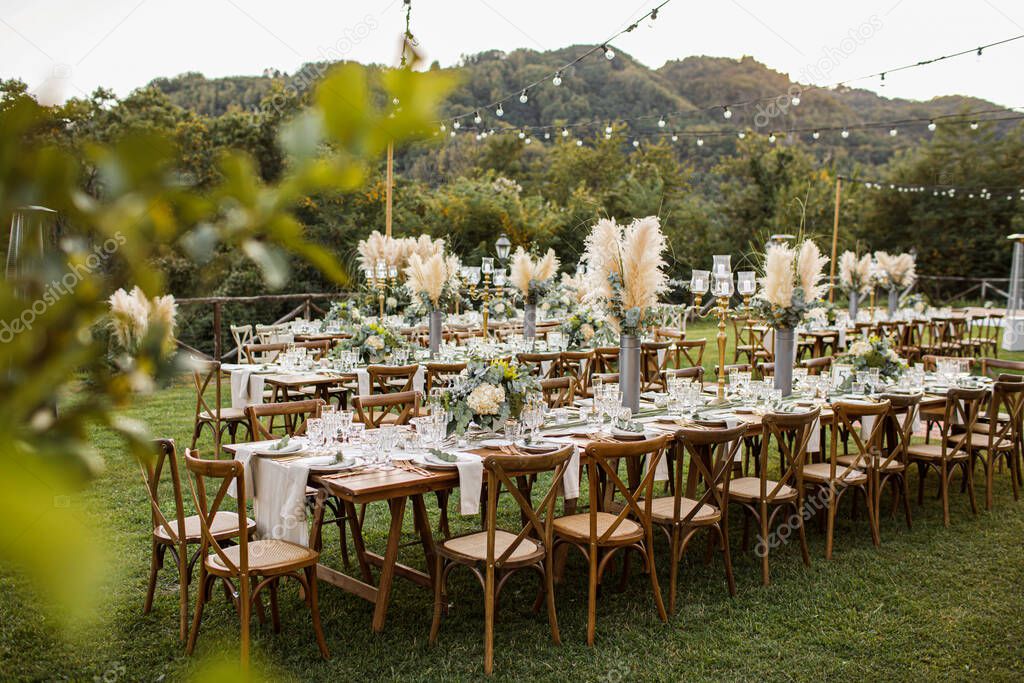 Wedding table set up in boho style with pampas grass and greenery, soft focus