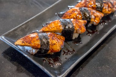 Sos ile foie gras suşi plaka üzerinde hizmet