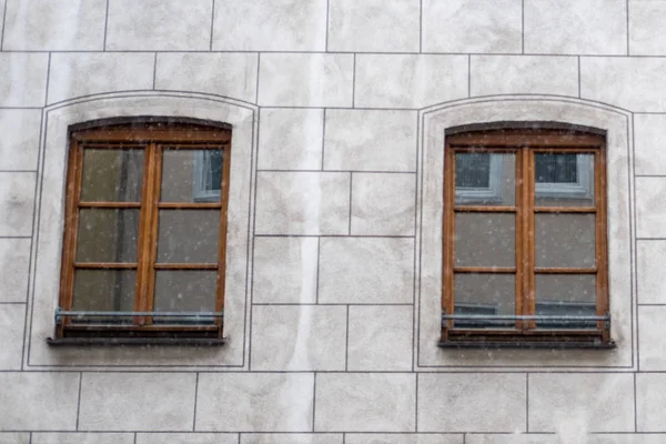 Snow falling with windows, building on the background.