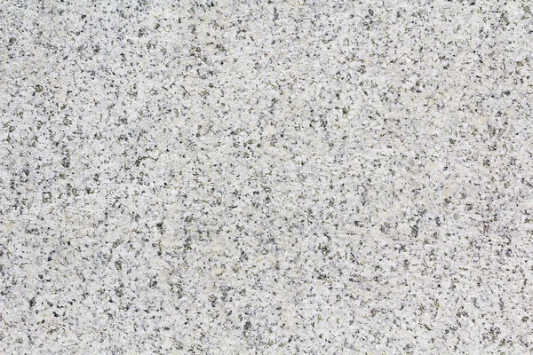 Texture gray granite. Smooth light stone texture. Uniform surface with stone grinding. Gray stone with dark inclusions. Material for decoration, background texture, interior design.