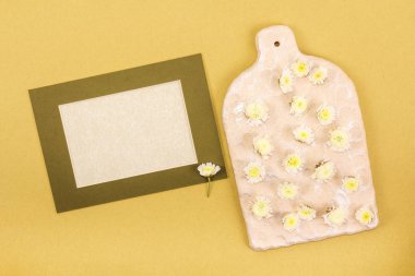 Düz yatıyordu, en iyi görünümü fotoğraf kadar sahte. Mockup çerçeve çiçek ve Sevgililer günü için koyu sarı arka plan üzerinde küçük sarı çiçekli dekoratif yönetim kurulu veya metin için yer ile düğün.