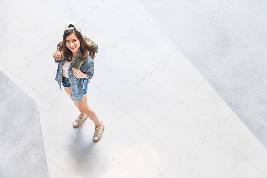 Young beautiful Asian backpack traveler, cute woman wearing hat looking up and smile, top view with copy space. Journey trip lifestyle, world travel explorer or Asia summer tropical tourism concept