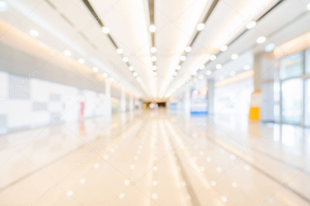 Blurred, defocused bokeh background of exhibition hall or convention center hallway. Business trade show event, modern white interior architecture, or commercial tradeshow conference seminar concept