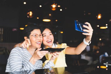 Bangkok, Tayland - 28 Ağustos 2018: Asya Anne ve kızı selfie fotoğrafta gıda ile birlikte restoranda, Samsung Galaxy Not 9 üzerinde S-kalem bluetooth uzaktan deklanşör kullanarak. Açıklayıcı yazı işleri.