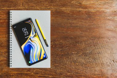 Bangkok, Tayland - 30 Ağustos 2018: Okyanus mavi Samsung Galaxy Not 9 sarı S kalem üstünde bir defter ile ahşap masa üzerinde kopya alanı ile. Açıklayıcı yazı işleri.