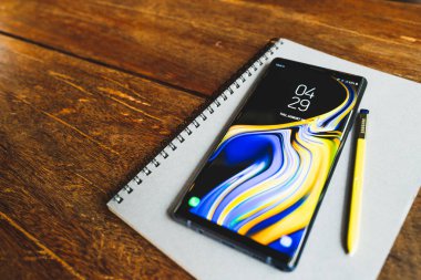 Bangkok, Tayland - 30 Ağustos 2018: Okyanus mavi Samsung Galaxy Not 9 sarı S kalem üstünde bir defter ile ahşap masa üzerinde kopya alanı ile. Açıklayıcı yazı işleri.