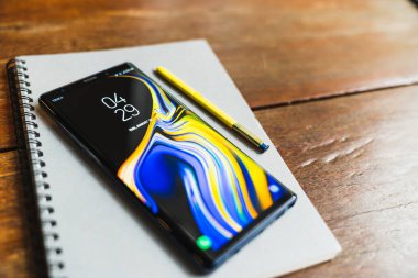 Bangkok, Tayland - 30 Ağustos 2018: Okyanus mavi Samsung Galaxy Not 9 sarı S kalem üstünde bir defter ile ahşap masa üzerinde kopya alanı ile. Açıklayıcı yazı işleri.