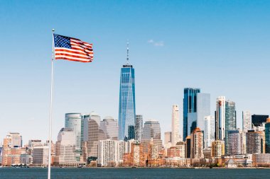 Arka planda New York city Manhattan adası ile güneşli bir günde Amerikan ulusal bayrağı. Amerika cityscape, ya da Amerika Birleşik Devletleri ulus sembolü kavramı