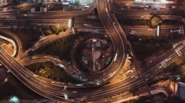 Hong Kong şehrinde birden fazla şeritli karayolu, dolambaçlı yol ve kavşak gece araba trafiğinin 4k Uhd üst görünümü zaman atlamalı. Banliyö, şehir hayatı veya kara taşımacılığı konsepti. Kamerayı uzaklaştırmak