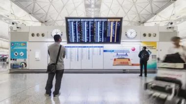 4k Uhd Zaman atlamalı kalabalık insanların varış kalkış tahtası kontrol ve Hong Kong havaalanı terminalinde yürüyüş. Hava taşımacılığı, yurt dışına seyahat veya banliyö yaşam tarzı kavramı. Efekti uzaklaştırma