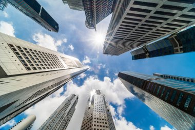 Singapur 'un iş bölgesinde gökdelen kulesi binaları. Güneşli bir günde bulutlar ve güneş parlar. Düşük açı. Asya finans ekonomisi, birleşme & satın alma, veya modern mimari kavramı