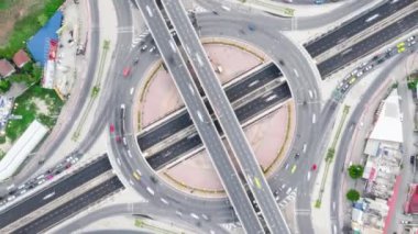 Dolambaçlı yolun yukarısındaki araç trafiği hızlandırılmış. İnsansız hava aracı üst görüntüsü. Toplu taşıma ya da banliyö hayatı kavramı. Uzaklaştır