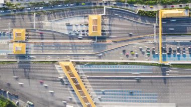Birden fazla şeritli otoyol ve gişe kapısındaki araç trafiğinin hızlandırılmış 4K sürümü, insansız hava aracı üst görüntüsü. Seyahat ulaşımı, şehir hayatı konsepti. Döndürme