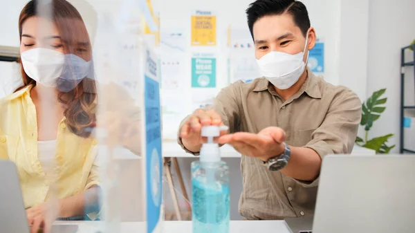 아시아 사업가들은 마스크를 소독제를 사용하여 씻으며 파티션 스탠드로 직장에서의 사회적 — 스톡 사진