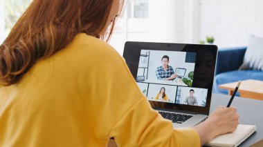 Genç Asyalı kadın video konferansı, iş arkadaşıyla internet üzerinden uzaktan görüşme, evde. Yeni normal yaşam tarzı, sosyal mesafeler, internet teknolojisi, iş kadını ev kavramından çalışma