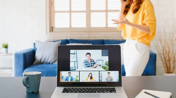 Young Asian woman on mobile phone call during video call conference, online remote meeting with business coworker at home. New normal lifestyle, social distancing, businesswoman work from home concept
