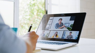 Asyalı adam video konferansı, iş arkadaşıyla internet üzerinden uzaktan görüşme, evde. Yeni normal yaşam tarzı, sosyal uzaklık, internet teknolojisi, iş adamı ev kavramından çalışma