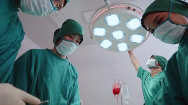 Bir grup Asyalı doktor, pratisyen ve hemşire hastane ameliyathanesinde ameliyat yapıyorlar. Sağlık hizmeti işi, tıbbi teknoloji konsepti