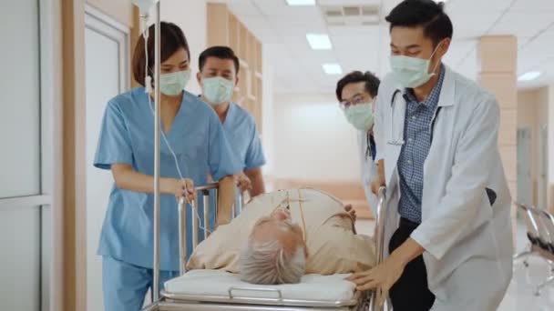 亚洲急救医生和护士小组戴着口罩 推着急救担架 将老年患者送往医院 医疗辅助医疗服务或医疗救援队的运作概念 — 图库视频影像