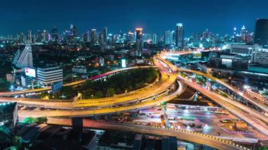 Gece vakti Bangkok, Tayland 'da karayolu kavşağındaki araç trafiği hızlandırılmış. Toplu taşıma, banliyö yaşam tarzı, Asya şehir hayatı konsepti. Yüksek açı görünümü, yakınlaştır
