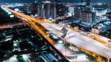 Otoban yolundaki araba trafiğinin zaman aşımı, gece geçiş kapısı. İnşaat vinci olan şehir manzarası. Şehir taşımacılığı, Asya şehir hayatı. Yüksek açı görünümü, yukarı eğ