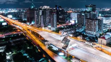 Otoban yolundaki araba trafiğinin zaman aşımı, gece geçiş kapısı. İnşaat vinci olan şehir manzarası. Şehir taşımacılığı, Asya şehir hayatı. Yüksek açı görünümü, yakınlaştır