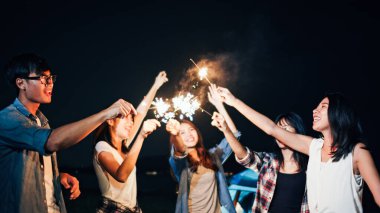 Asyalı bir grup genç üniversite öğrencisi, plaj kampı çadırında birlikte şarkı söyleyip dans ediyorlardı. Parti insanları, dostluk ilişkisi ya da açık hava kamp aktivitesi konsepti.