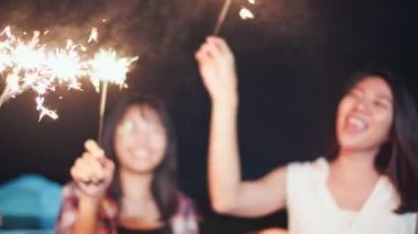 Asyalı bir grup genç üniversite öğrencisi, plaj kampı çadırında birlikte şarkı söyleyip dans ediyorlardı. Parti insanları, dostluk ilişkisi ya da açık hava kamp aktivitesi konsepti.