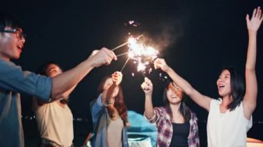Asyalı bir grup genç üniversite öğrencisi, plaj kampı çadırında birlikte şarkı söyleyip dans ediyorlardı. Parti insanları, dostluk ilişkisi ya da açık hava kamp aktivitesi konsepti.