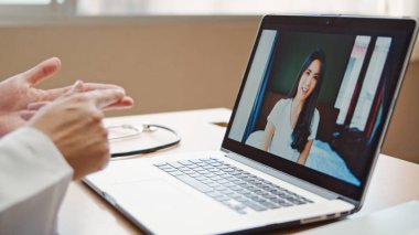 Doktor online video araması tedaviyi açıklıyor. Hastanedeki dizüstü bilgisayarla evden bağlanan Asyalı hasta ile semptom kontrolü. Telemedikal, Covid-19 yeni normal sağlık hizmeti kavramı