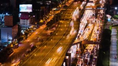 Kalabalık araba trafiğinin gece otoyolda ya da otobanda süratle ilerlemesi. Şehir taşımacılığı, Asya şehir hayatı. Yüksek açılı şehir manzarası, aşağı eğ