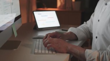 Asyalı adam ofis bilgisayarında gece geç saatlere kadar tek başına çalışıyor. Yorgun ve işten dolayı stresli. Fazla çalışma, fazla mesai, işkolik insanlar, sağlık sorunları, ya da ofis sendromu konsepti.