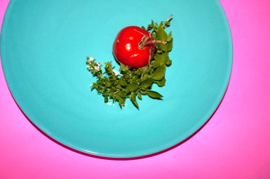 Domates, şehir bahçesinden kesilmiş çiçeklerle çevrili Resca dalı albhaca ile çevrili.