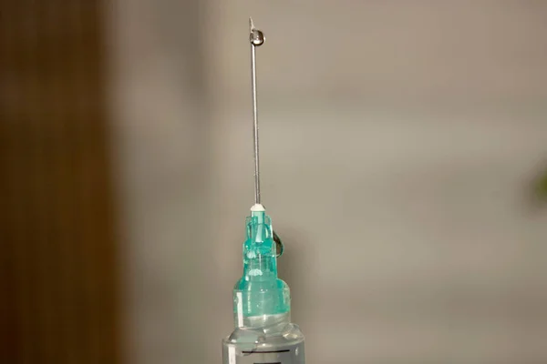 Syringe expelling liquid to remove air through the needle before applying vaccine