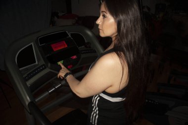 Meksikalı bir kadın Mexico City 'de koşu bandında fiziksel antrenmana başlıyor.