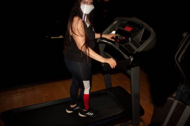 Mexico City 'de fiziksel ve kardiyovasküler dayanıklılık için koşu bandında spor kıyafetleri, şeffaf ekran ve salgın Covid-19 maskesi giyerek yeni realite kadın eğitimine başlıyor.