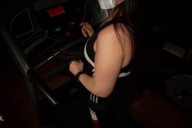 Mexico City 'de bir GYM' de yürüyen bir kadın yüz ve ağız kapaklarını şeffaf ekranla kapatarak salgın covid-19 'da fiziksel eğitim alıyor.