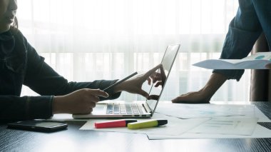 table.business kavramı üzerinde modern ofis dizüstü bilgisayar ile bir toplantı sırasında tartışırken iş adamları ahşap