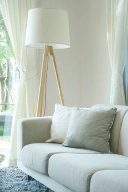 Rahat kanepe yastık ve oturma odasında duran lamba ile