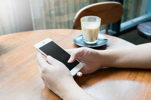 woman hand using smartphone for mobile transaction or shopping online in coffee shop. (fintech, financial and technology concept)