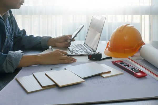 akıllı telefon, laptop, blueprint ve malzemeler örnek - iş ve endüstriyel kavramı ile tabloda çalışma mimar