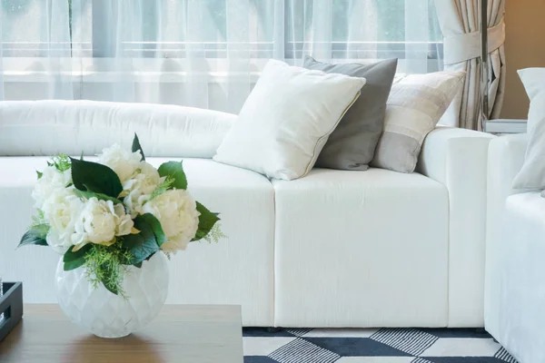 Flower vase at center table with white sofa in living room