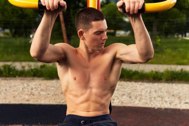 Güçlü adam zor egzersizleri ile sokak egzersiz yapın ve kamera için poz