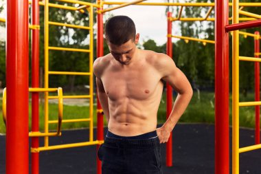 Güçlü adam zor egzersizleri ile sokak egzersiz yapın ve kamera için poz